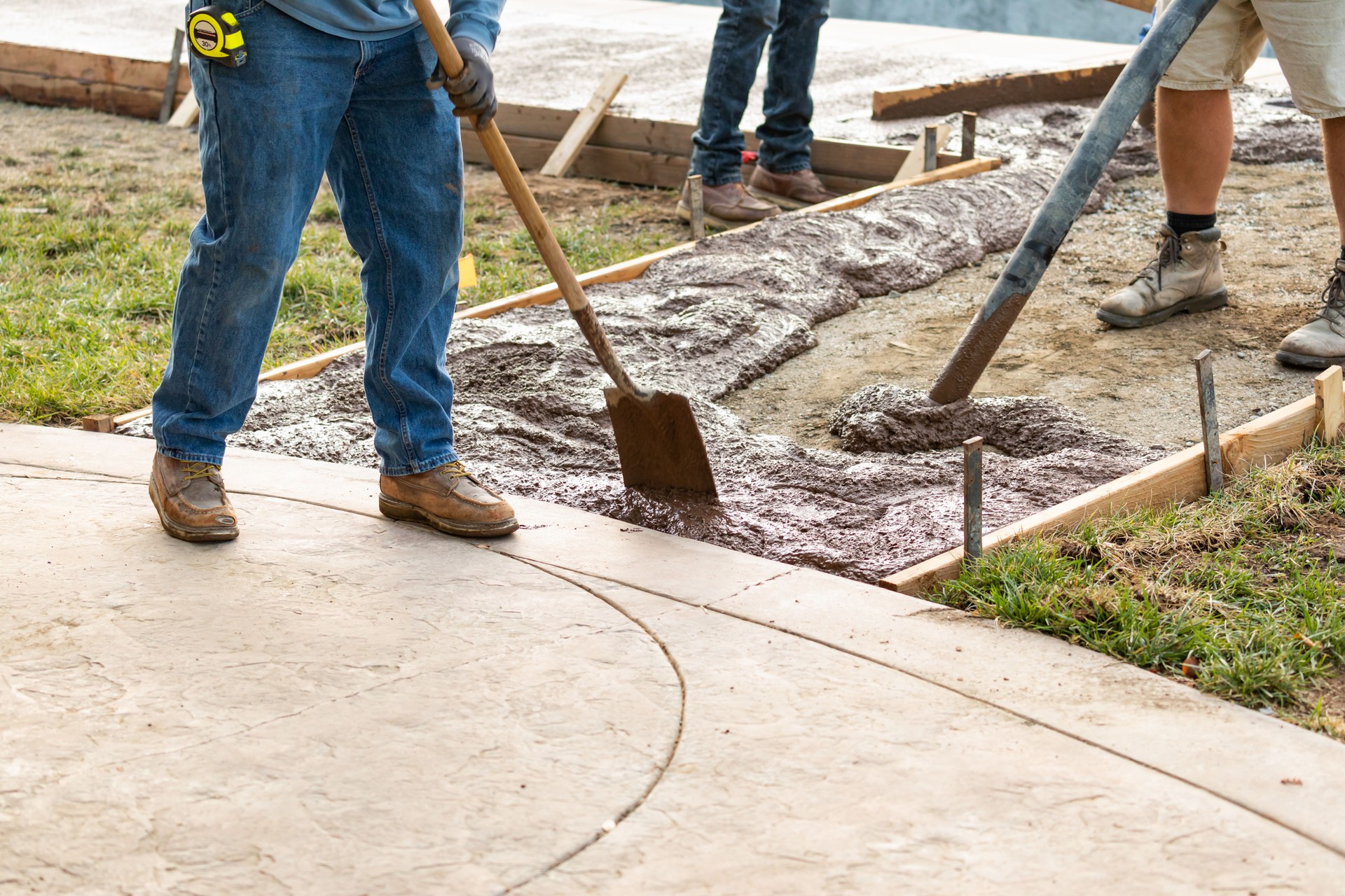 Construction Worker Pouring Wet Deck Cement Into Wooden Frame