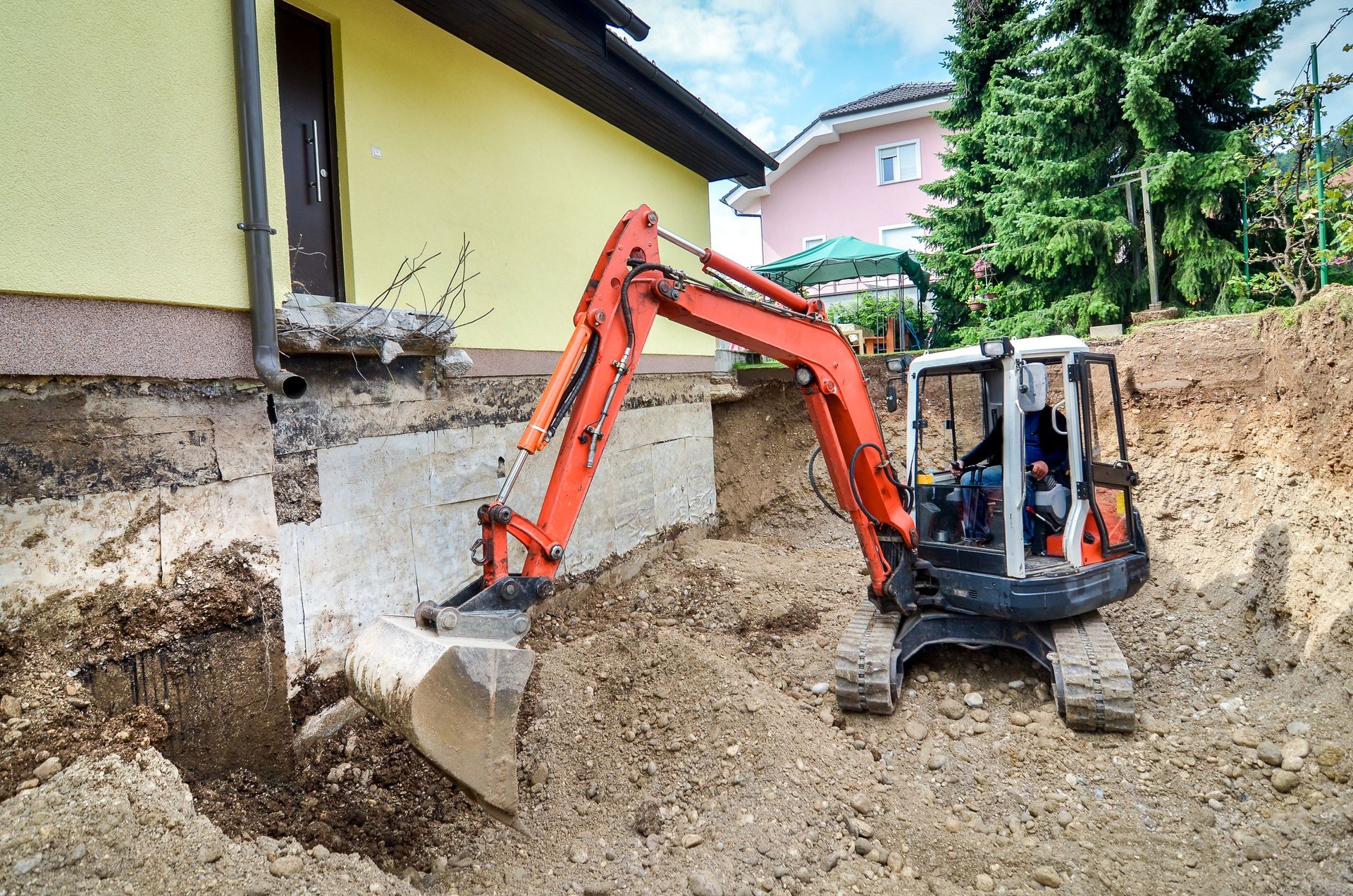 Family house is being rebuilt with the help of excavator